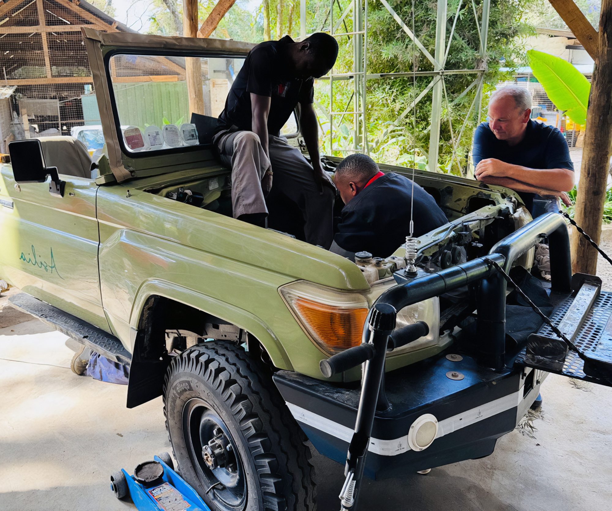 Technicians working on an Asilia safari vehicle during a Tembo electric conversion
