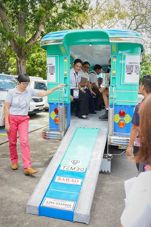 Passengers inside an electric jeepney with its accessible ramp lowered